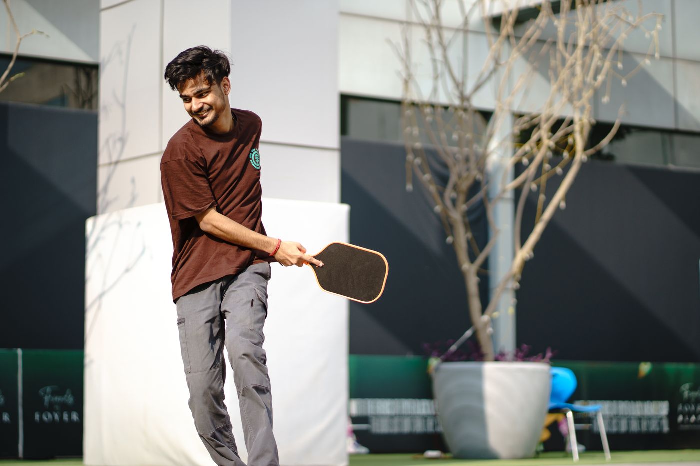 A smiling pickleball player ready for a friendly game — illustrative photography